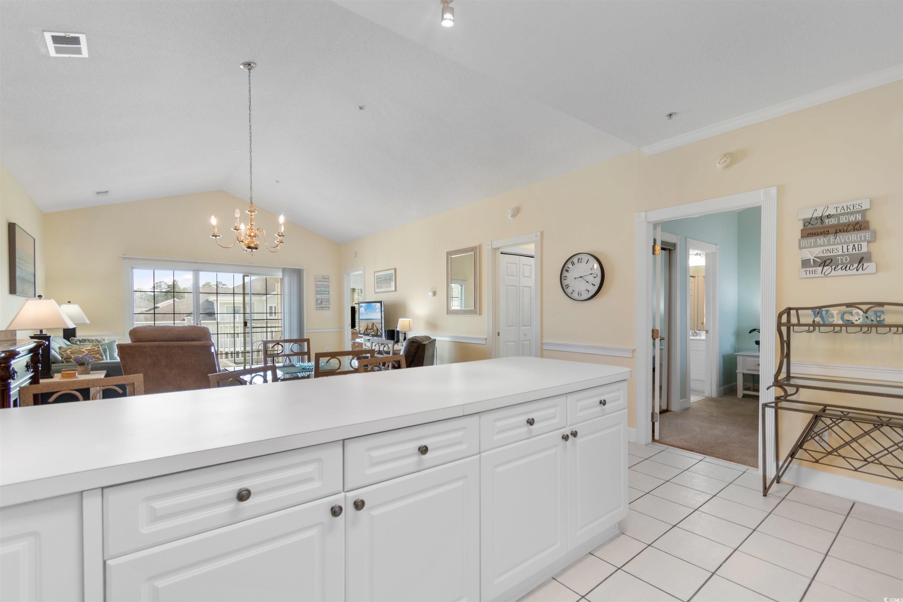 4856 Carnation Circle, Unit 302 Myrtle Beach, SC 29577 - Photo 28 of 28 Kitchen featuring open floor plan, light countertops, lofted ceiling, white cabinets, and a chandelier