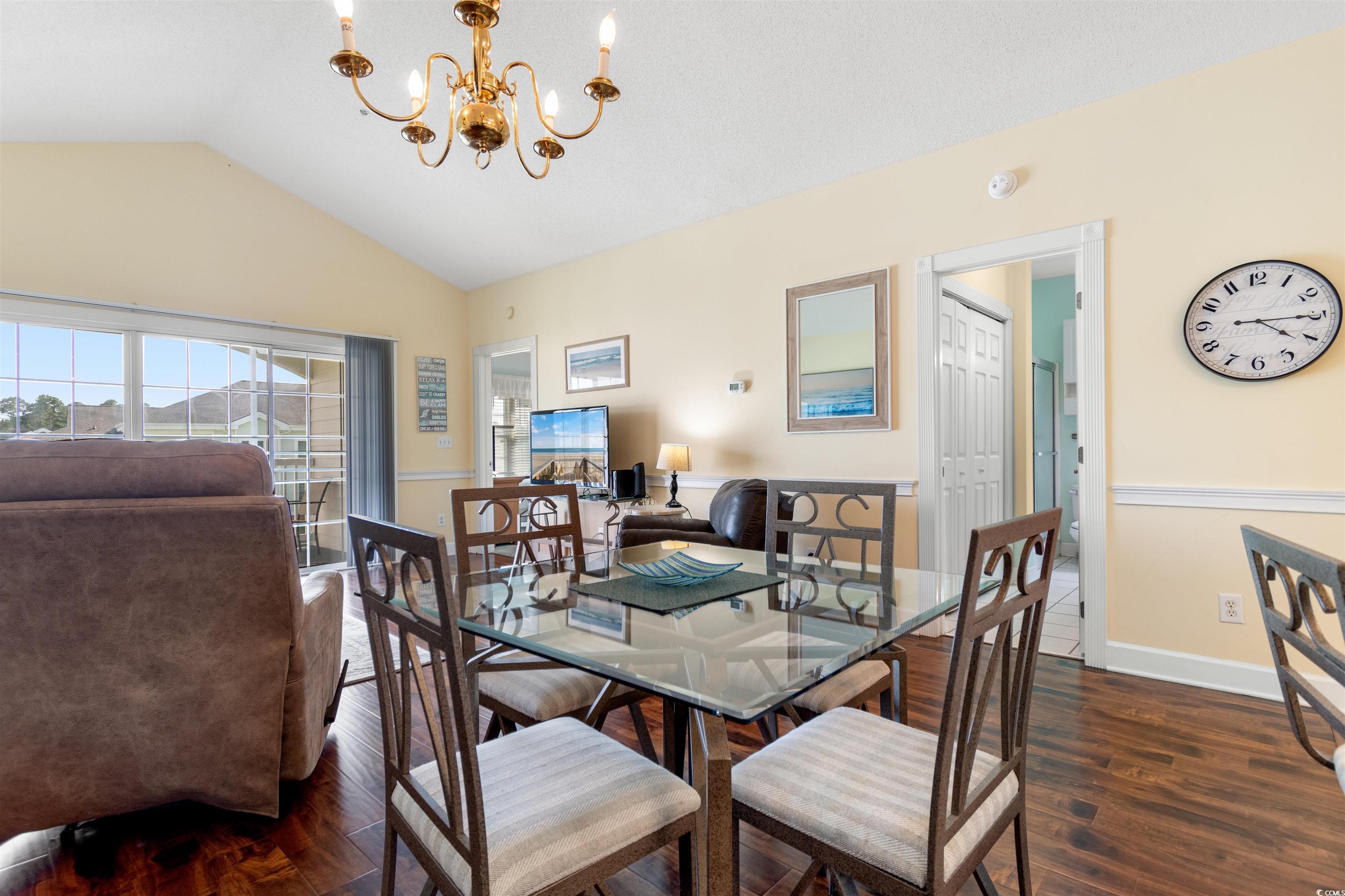 4856 Carnation Circle, Unit 302 Myrtle Beach, SC 29577 - Photo 17 of 28 Dining room featuring vaulted ceiling, dark wood-style flooring, and a chandelier