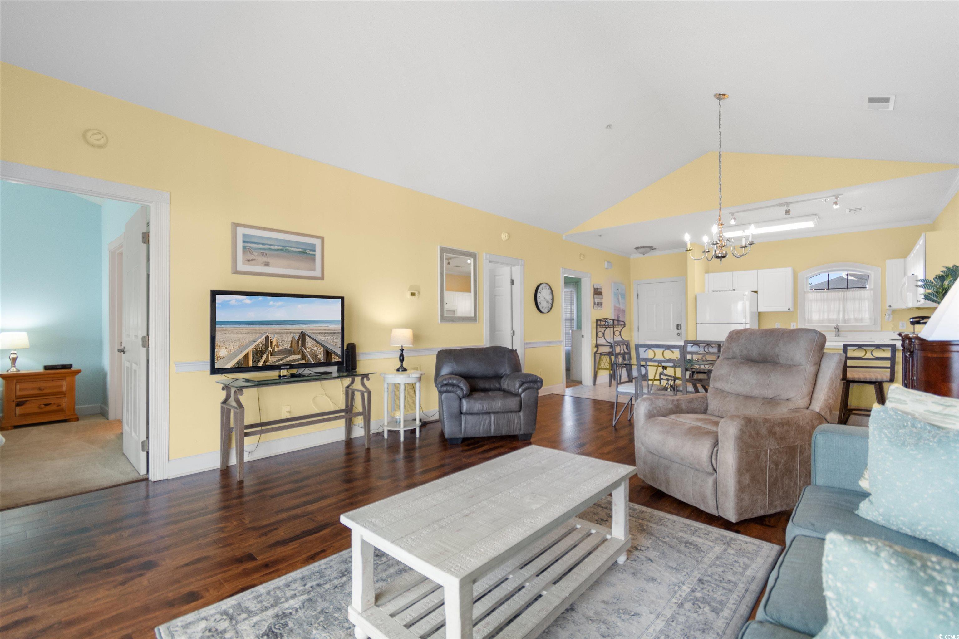 4856 Carnation Circle, Unit 302 Myrtle Beach, SC 29577 - Photo 7 of 28 Living area featuring vaulted ceiling, wood finished floors, and a chandelier