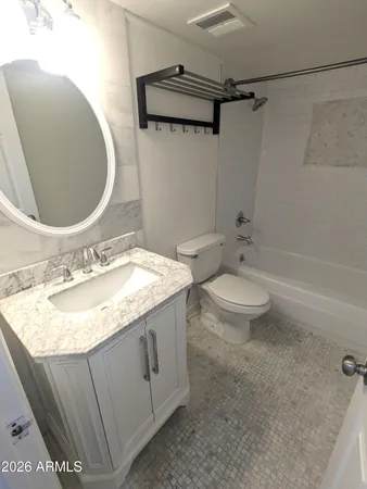 a bathroom with a granite countertop sink a toilet and bathtub