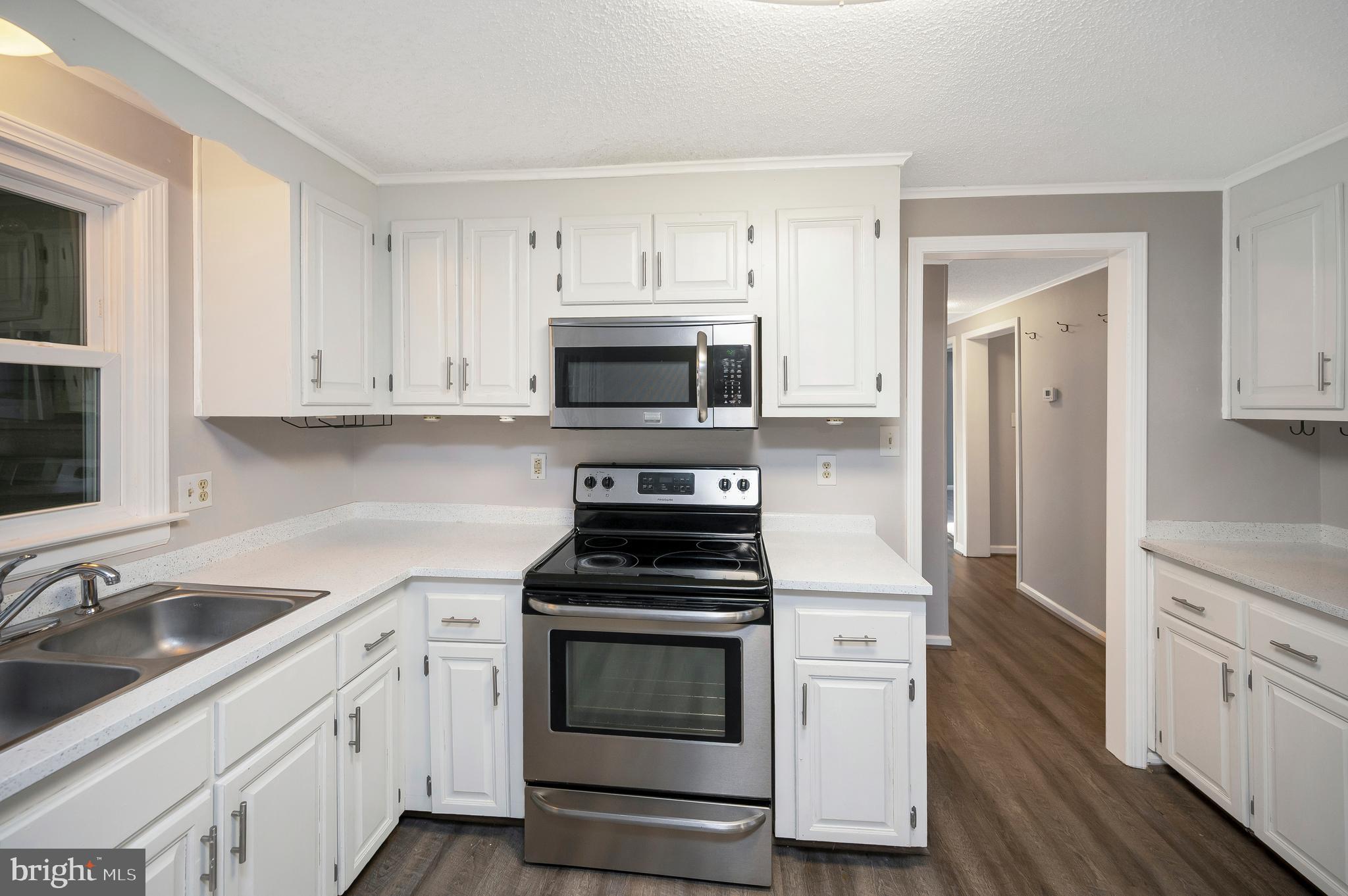 12402 Toll House Road Spotsylvania, VA 22551 - Photo 24 of 59 a kitchen with white cabinets and stainless steel appliances