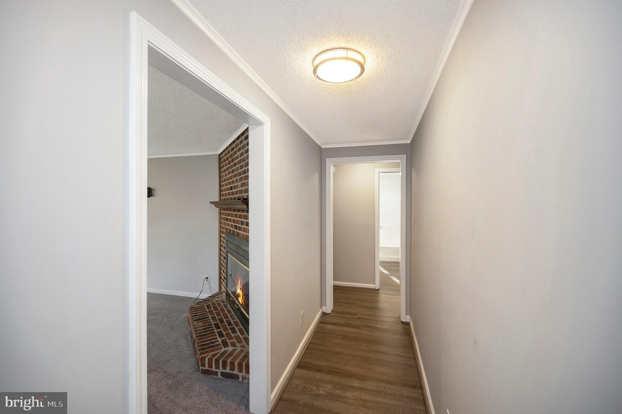 12402 Toll House Road Spotsylvania, VA 22551 - Photo 9 of 59 a view of a hallway with wooden floor and a bathroom