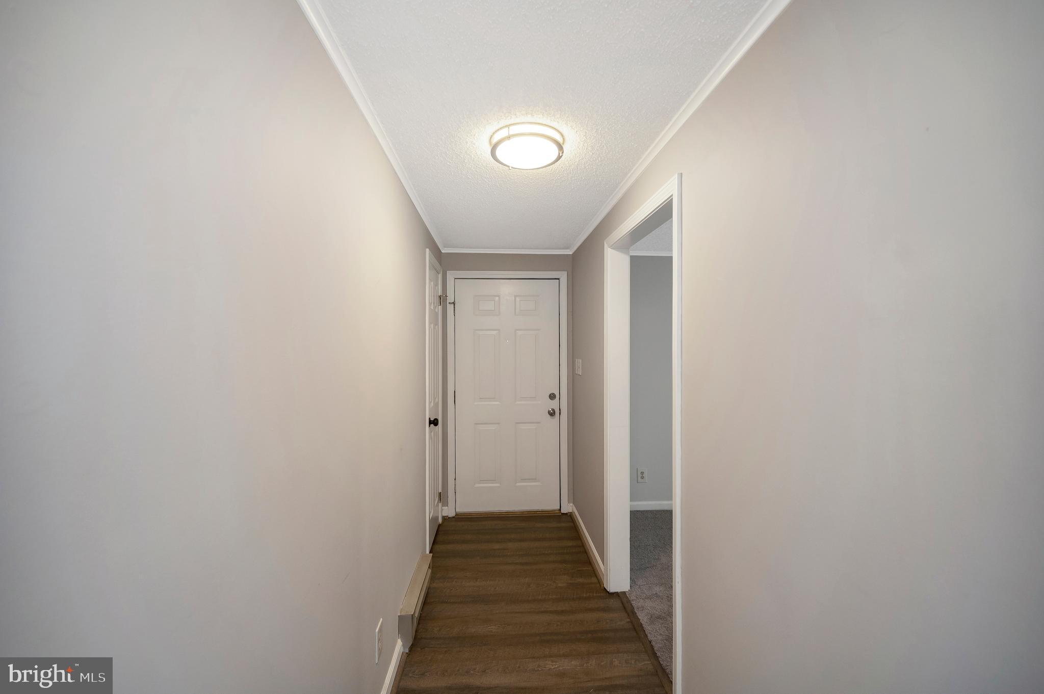 12402 Toll House Road Spotsylvania, VA 22551 - Photo 10 of 59 a view of a hallway with wooden floor and a bathroom