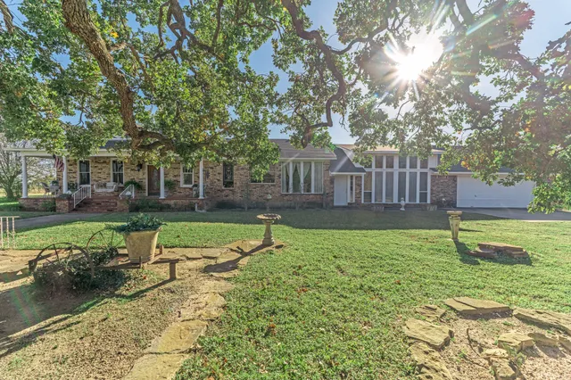 a view of a house with backyard and sitting area