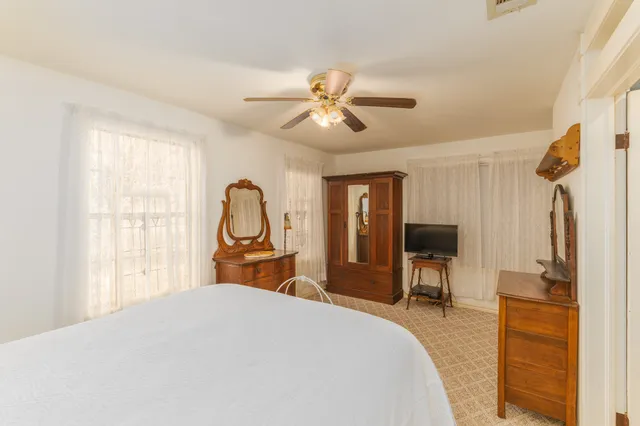 a dining room with wooden floor a chandelier a glass table and chairs