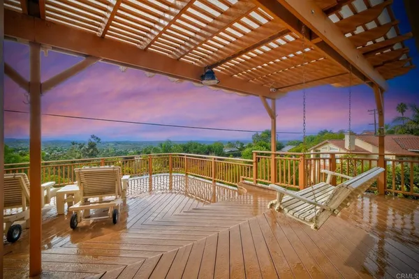 a view of a balcony with wooden floor and outdoor seating