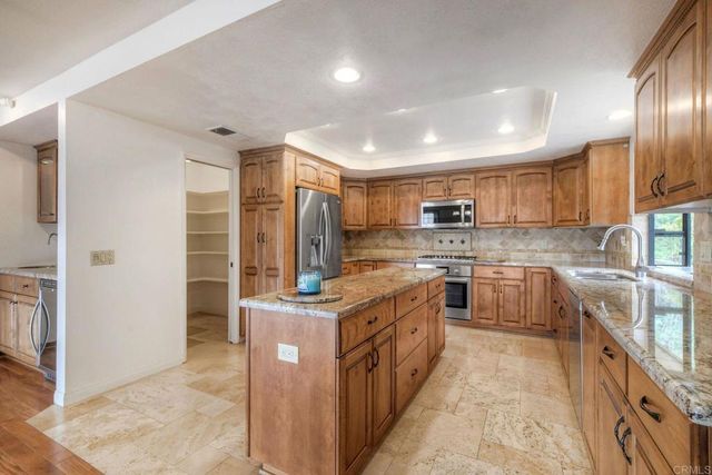 a kitchen with stainless steel appliances granite countertop a stove top oven a sink and dishwasher