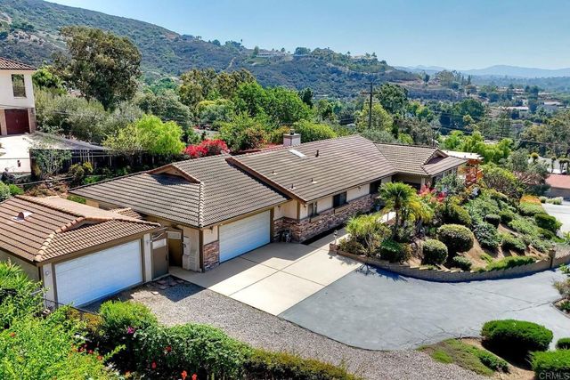 an aerial view of a house with a garden and mountain view
