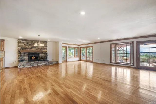 a view of empty room with fireplace and wooden floor