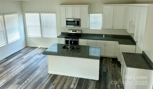 a kitchen with a wooden floor and a stove top oven