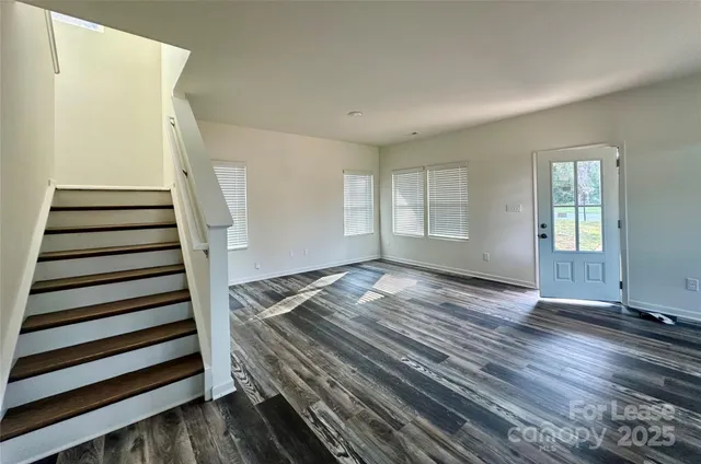 a view of a room with wooden floor and white walls
