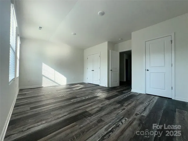 a view of a room with wooden floor and a window