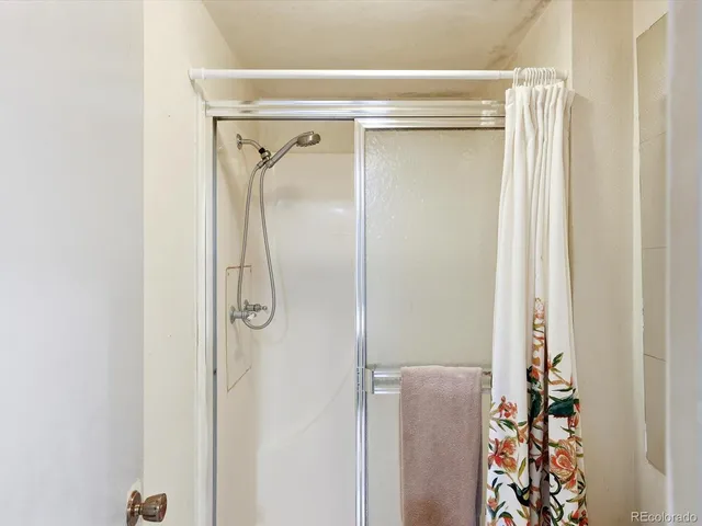 a bathroom with a shower and a glass door