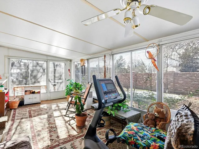 a living room with patio furniture and a floor to ceiling windows
