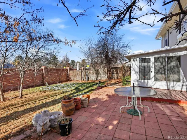 a view of a patio with table and chairs next to a yard