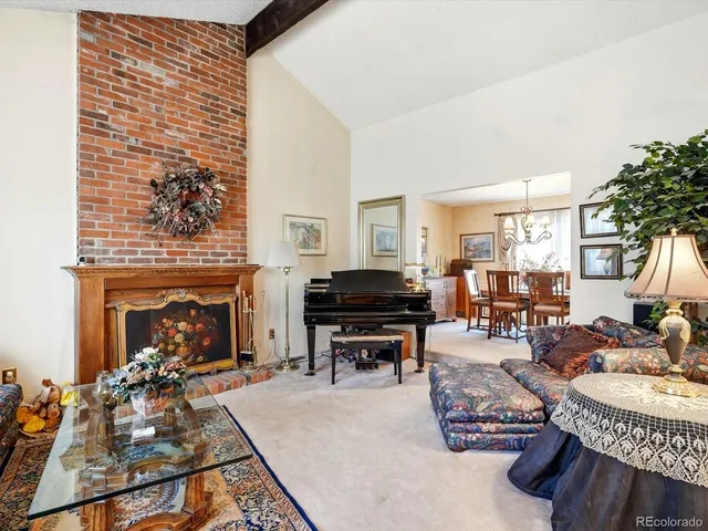 a living room with furniture a fireplace and large windows