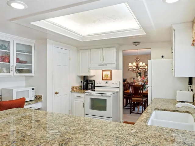a kitchen with a stove a refrigerator and a dining table view