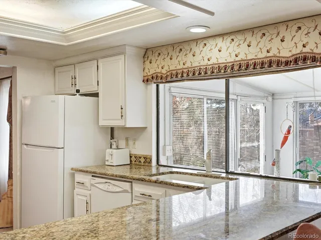 a kitchen with stainless steel appliances granite countertop a refrigerator a sink and a stove