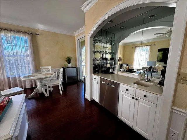 a kitchen with stainless steel appliances granite countertop a table chairs and a refrigerator