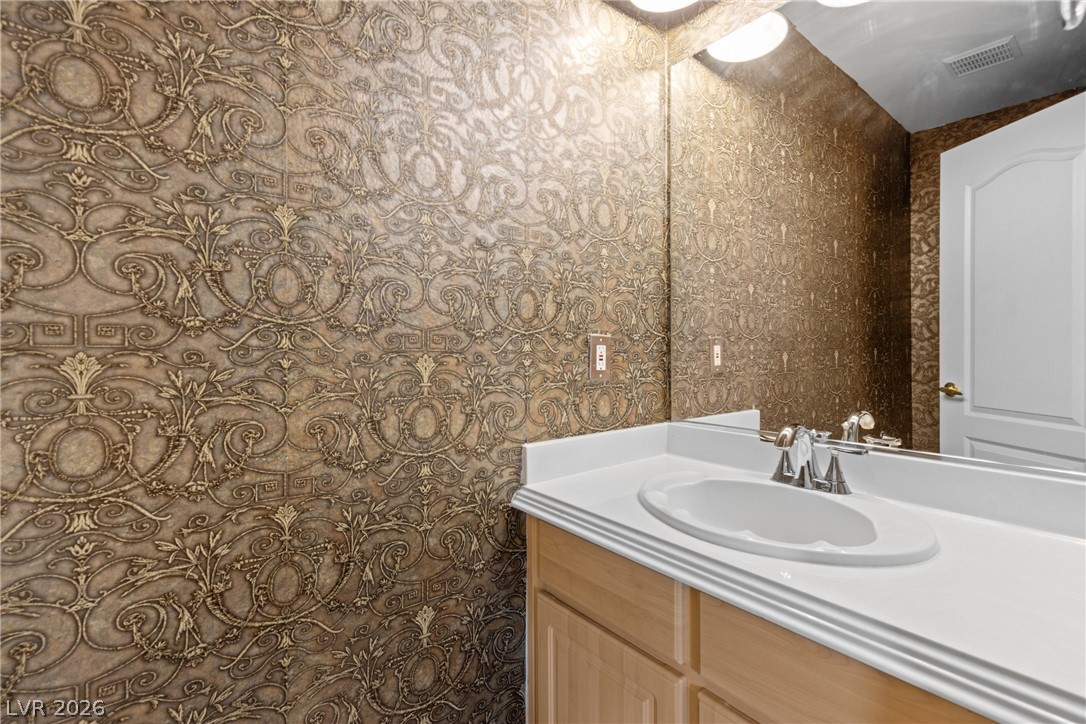 8934 Deep Ridge Court Las Vegas, NV 89178 - Photo 13 of 47 Ornate wallpaper and a polished vanity elevate this powder room.