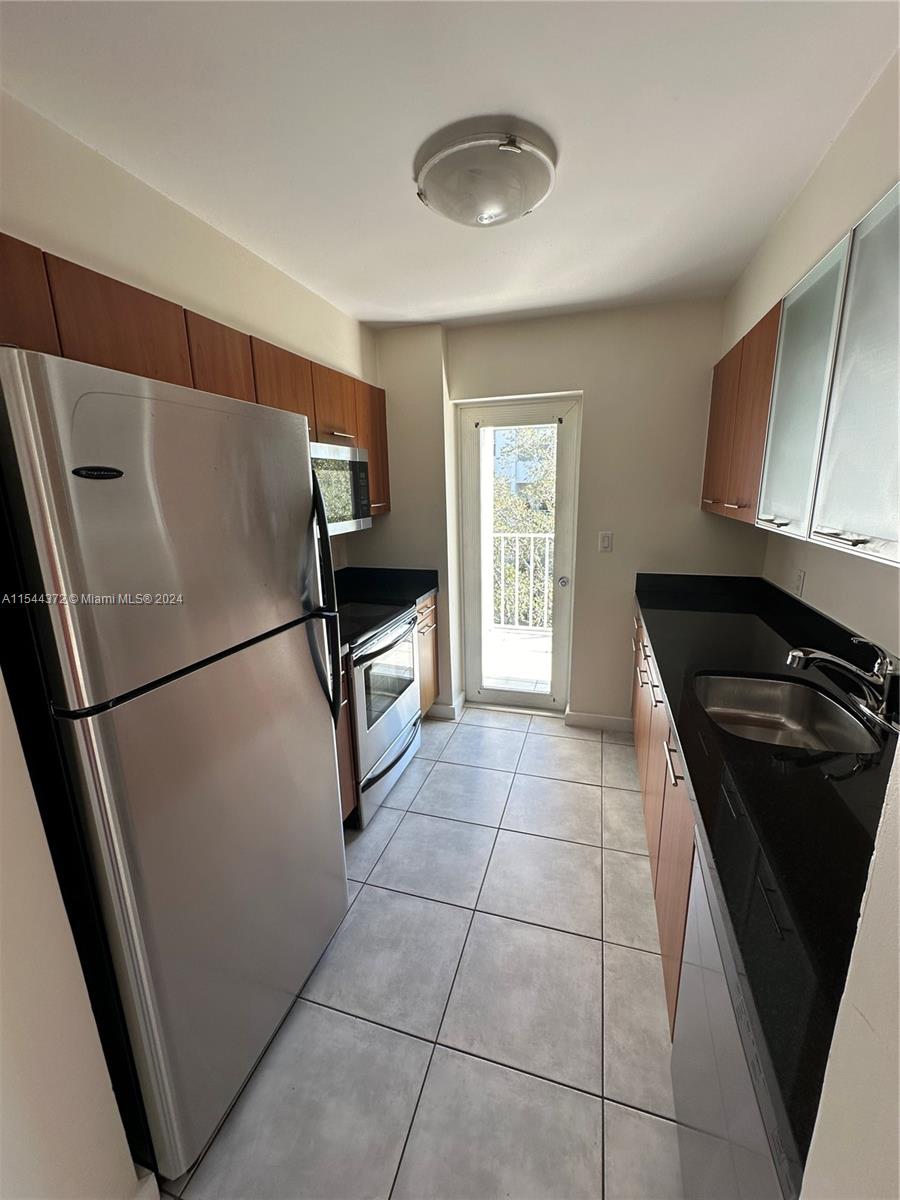 Nirvana Condominiums Miami, FL 33138 - Photo 13 of 13 a kitchen with a refrigerator and a stove top oven