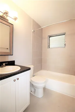 a bathroom with a granite countertop sink a toilet and a mirror