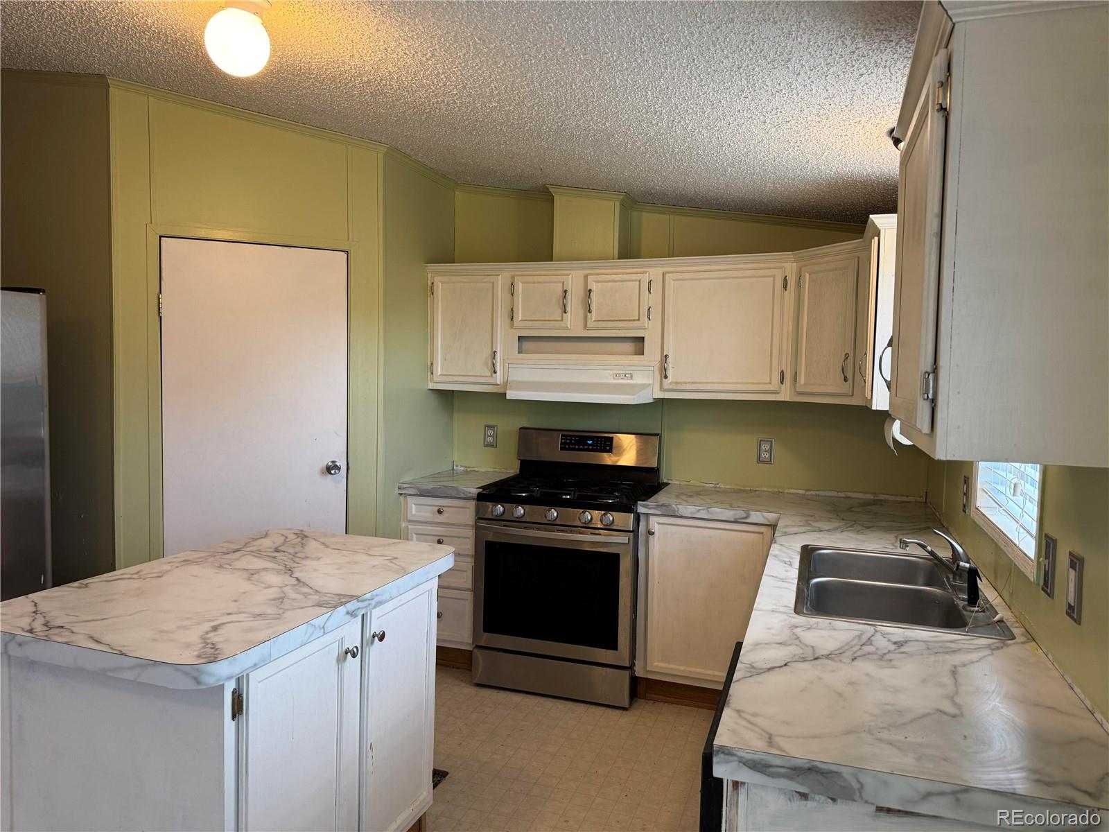 28983 County Road Aguilar, CO 81020 - Photo 12 of 24 a kitchen with granite countertop a stove sink and refrigerator