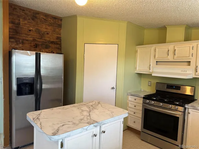 a kitchen with stainless steel appliances granite countertop a refrigerator and a stove