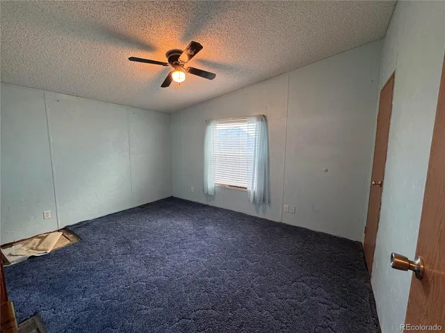 an empty room with closet and windows