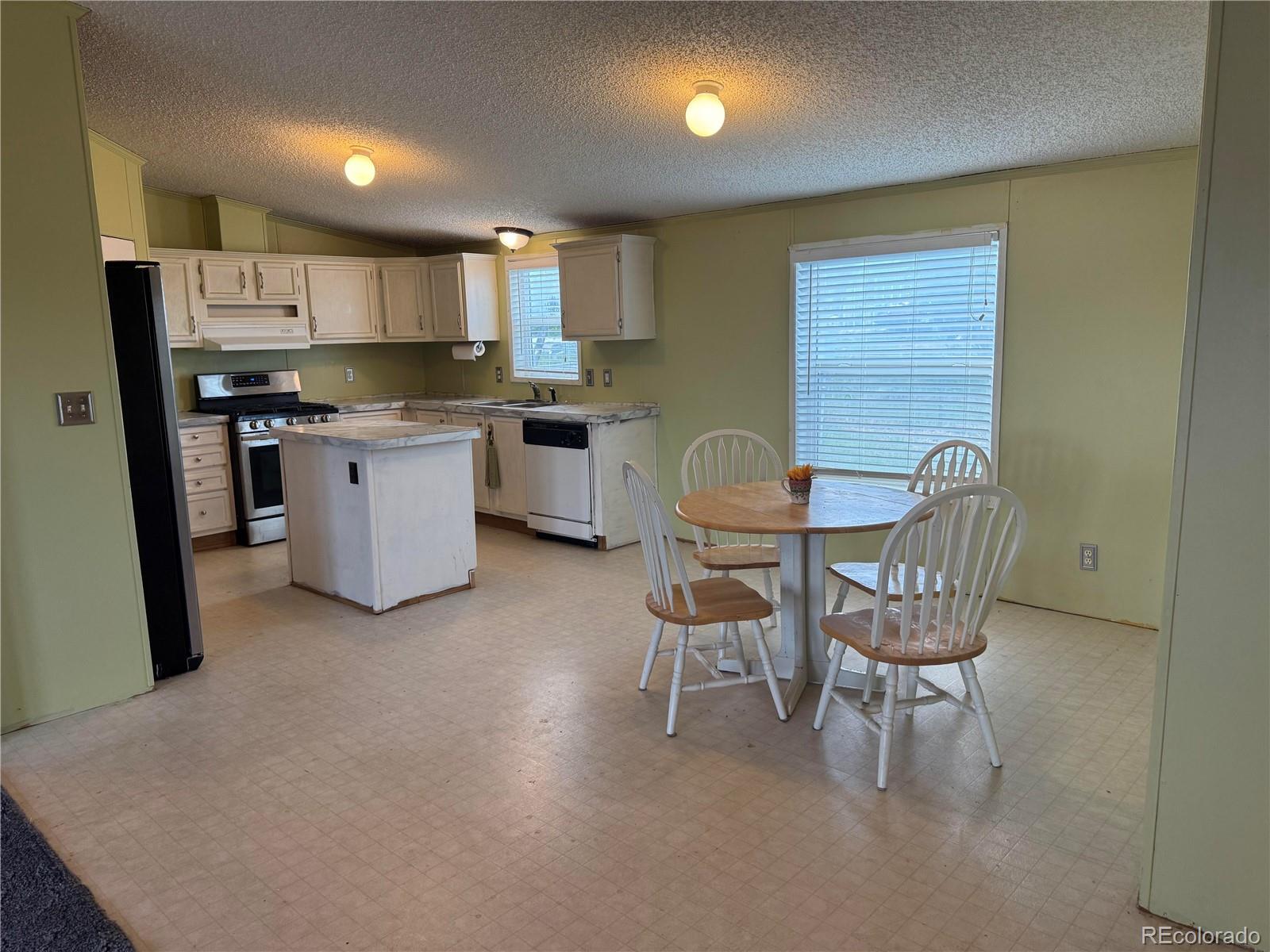 28983 County Road Aguilar, CO 81020 - Photo 10 of 24 a kitchen with stainless steel appliances kitchen island granite countertop a sink a stove a dining table and chairs