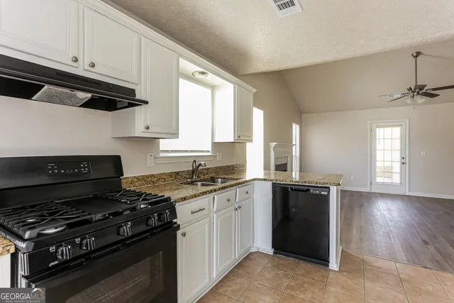 a kitchen with granite countertop a stove and a sink