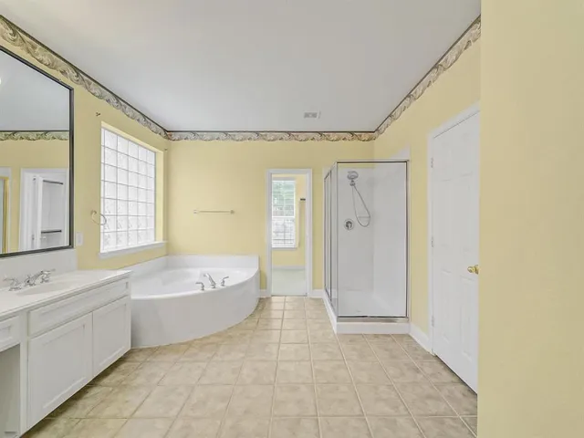 a spacious bathroom with a tub shower sink and mirror