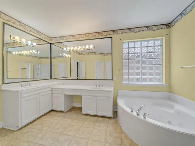 a bathroom with a large tub sink and double vanity