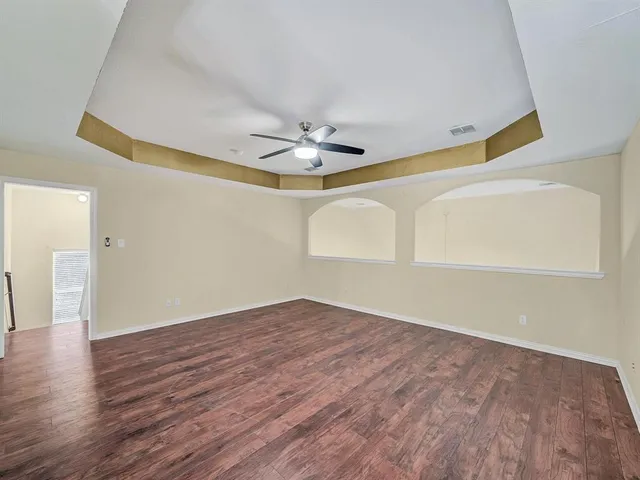 a view of an empty room with wooden floor