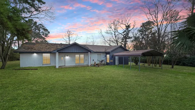 a front view of a house with a yard and trees