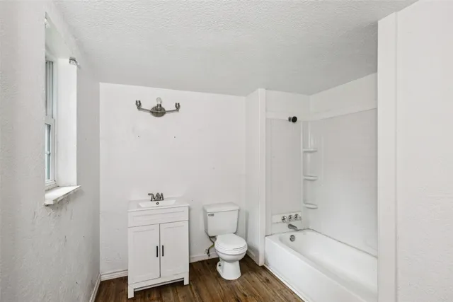 a bathroom with a granite countertop toilet a sink and bathtub