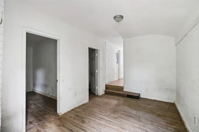 an empty room with wooden floor and closet