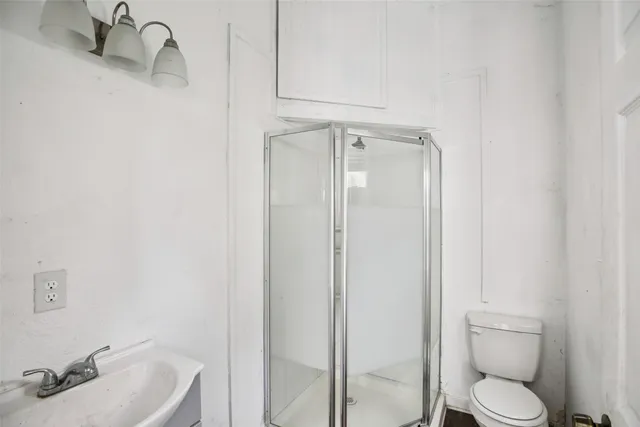a bathroom with a sink a toilet and shower
