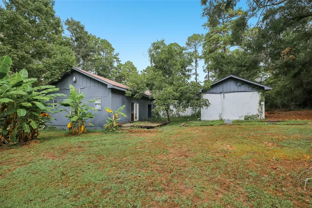 a view of a house with backyard and trees
