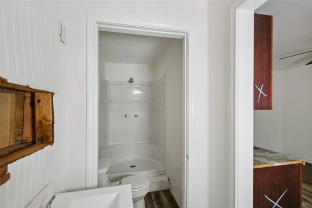 a bathroom with a bathtub shower sink vanity and toilet