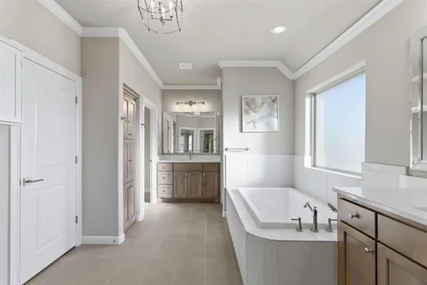 a bathroom with a tub a sink and a large mirror