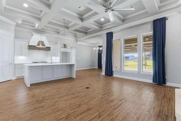 a view of a kitchen with wooden floor and a ceiling fan