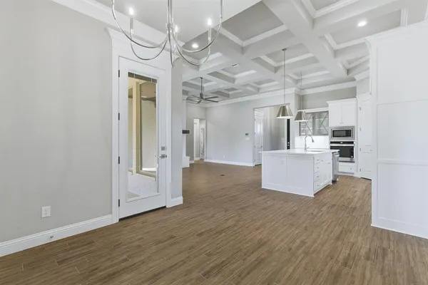a view of a kitchen with wooden floor and a refrigerator