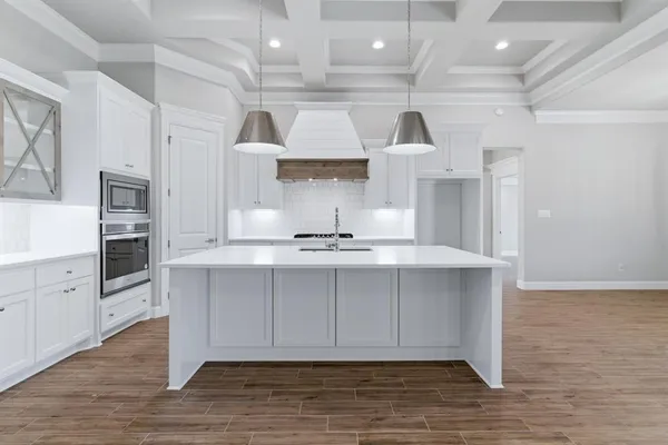 a kitchen with stainless steel appliances granite countertop a sink a stove and a wooden floors