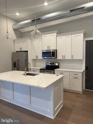 a kitchen with a refrigerator a sink and cabinets
