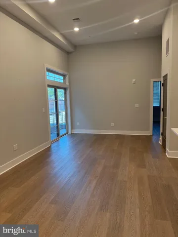 an empty room with wooden floor and entrance