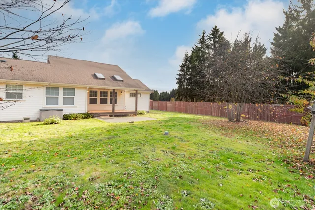 a view of yard with green space and wooden fence