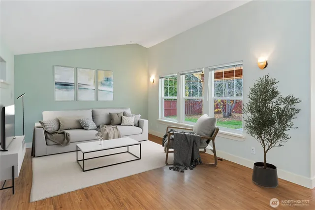 a living room with furniture a potted plant and a table