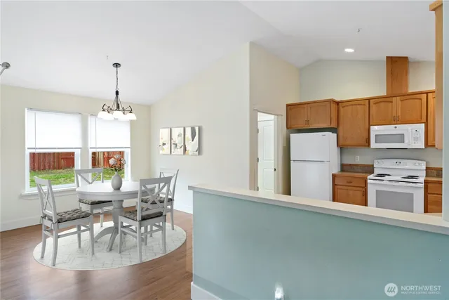 a dining room with furniture a chandelier and wooden floor