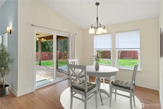 a kitchen with wooden floors and white stainless steel appliances